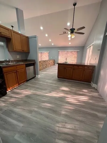 a kitchen with stainless steel appliances kitchen island granite countertop a refrigerator a sink and a stove