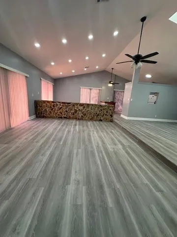 a view of a room with wooden floor staircase and a kitchen