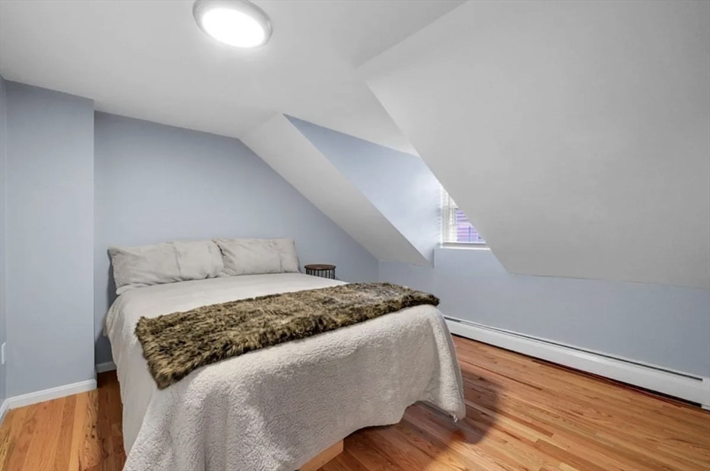 80 Park Street, Unit A Chelsea, MA 02150 - Photo 5 of 11 a bedroom with a bed and wooden floor