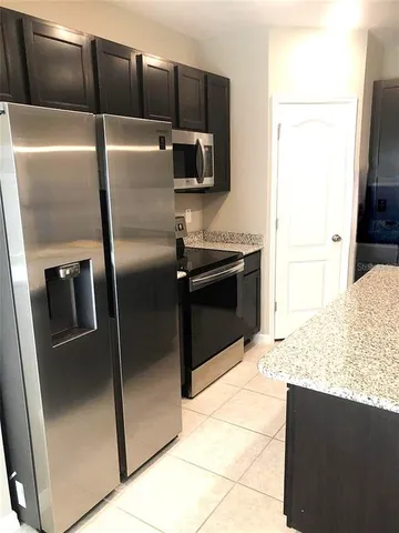 a kitchen with granite countertop a sink and a wooden cabinets