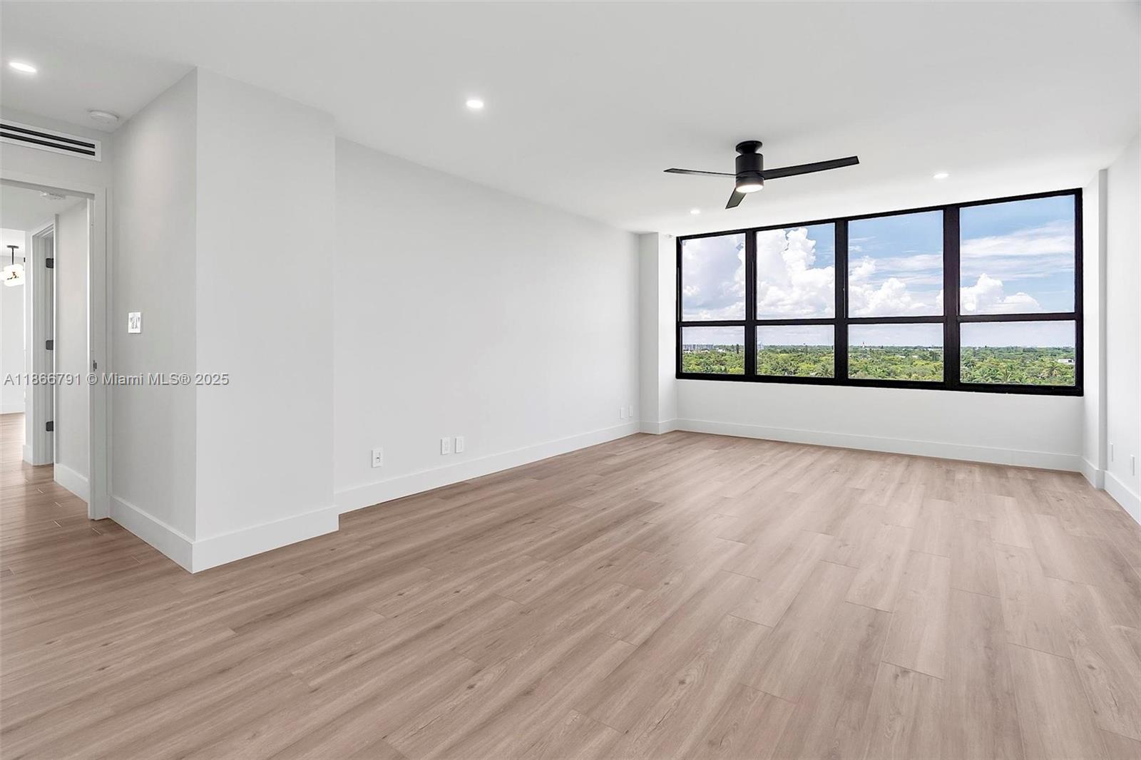 780 Northeast 69th Street, Unit 910 Miami, FL 33138 - Photo 11 of 26 wooden floor in an empty room with a window