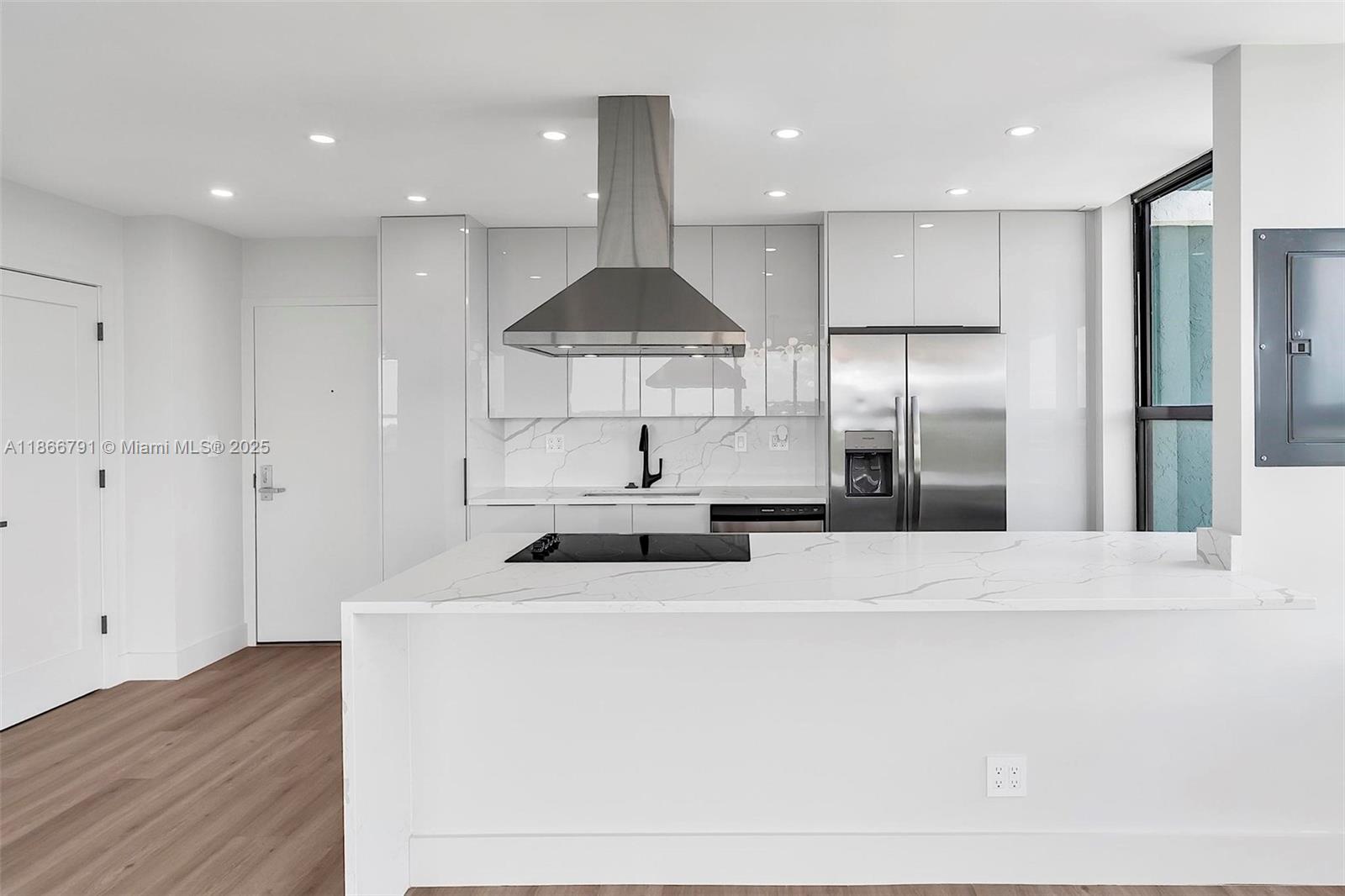 780 Northeast 69th Street, Unit 910 Miami, FL 33138 - Photo 4 of 26 a kitchen with stainless steel appliances a refrigerator a sink a stove a microwave and white cabinets