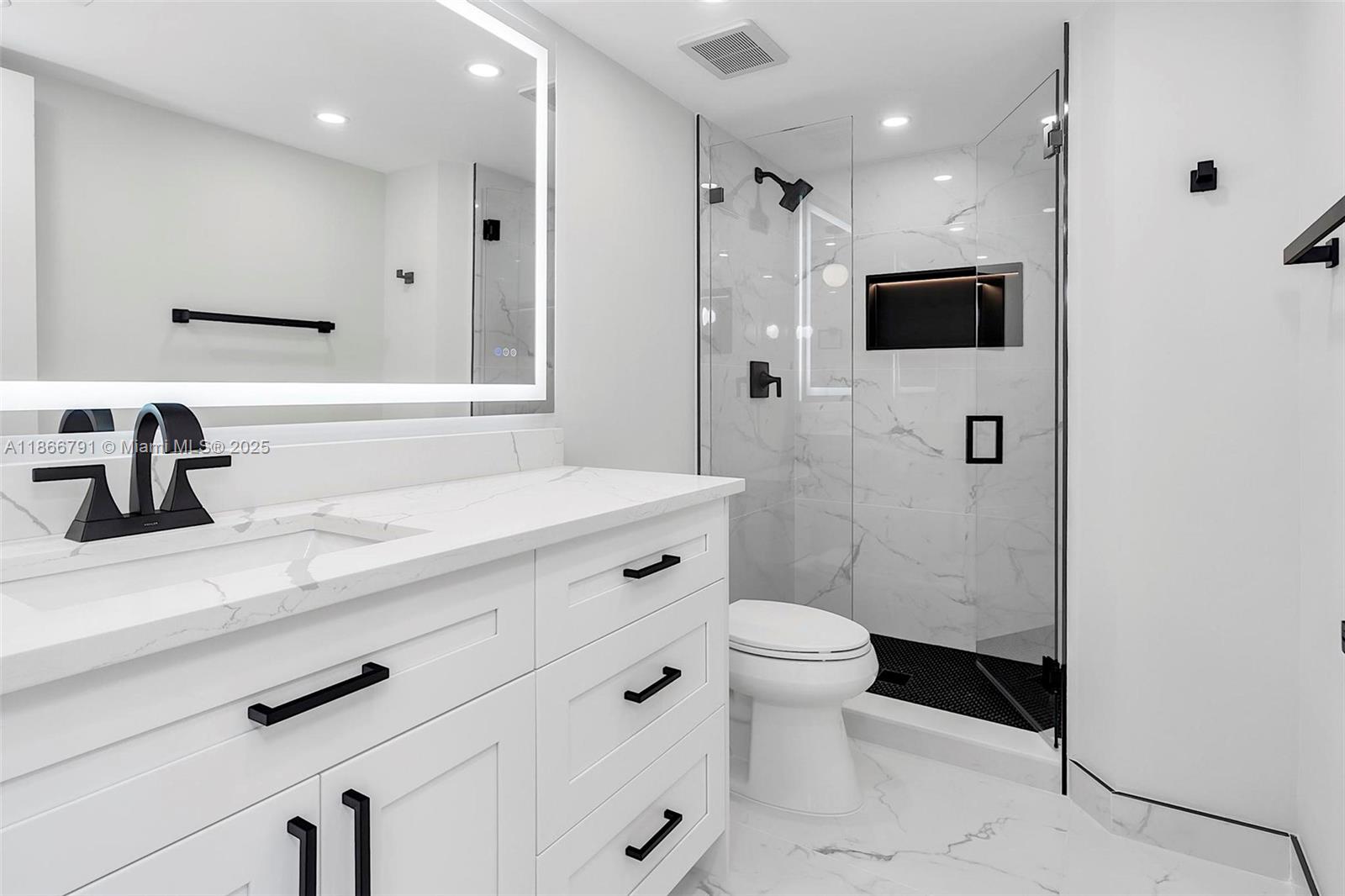 780 Northeast 69th Street, Unit 910 Miami, FL 33138 - Photo 9 of 26 a bathroom with a sink a toilet a shower and mirror