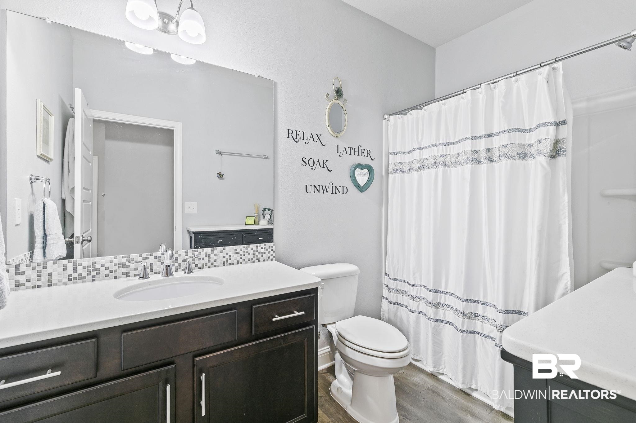 6867 Spaniel Drive, Unit B Daphne, AL 36527 - Photo 20 of 36 Bathroom with tasteful backsplash, a shower with curtain, vanity, wood-type flooring, and toilet