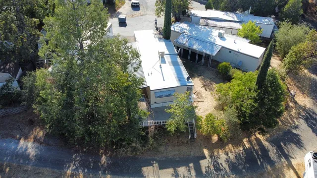 an aerial view of a house with a yard and mountain view