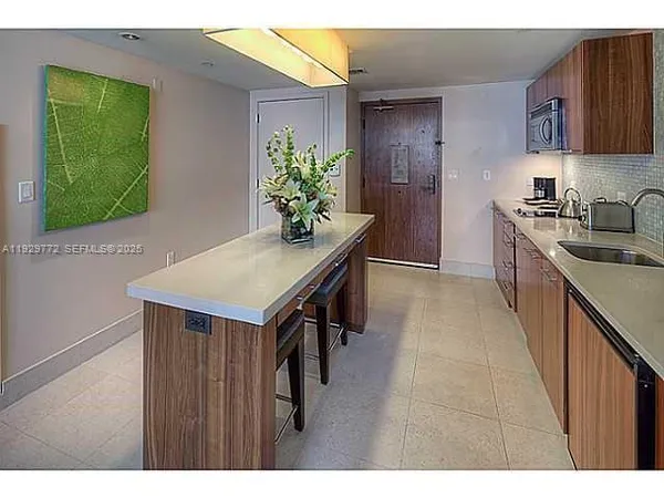 a kitchen with kitchen island stainless steel appliances a sink stove and refrigerator