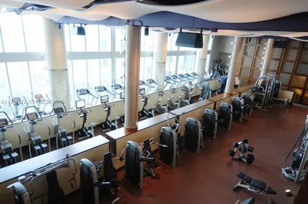 a very nice looking room with many windows and furniture
