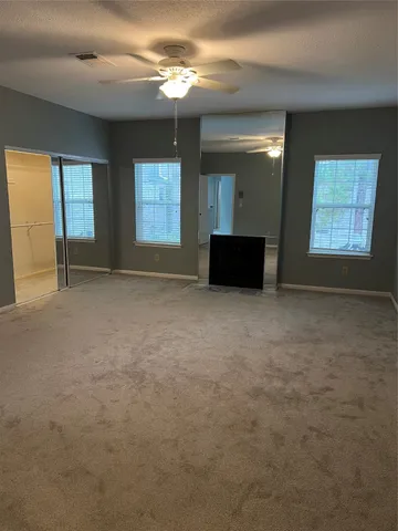 en empty room with windows and fireplace