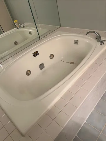 a bathroom with a tub and mirror