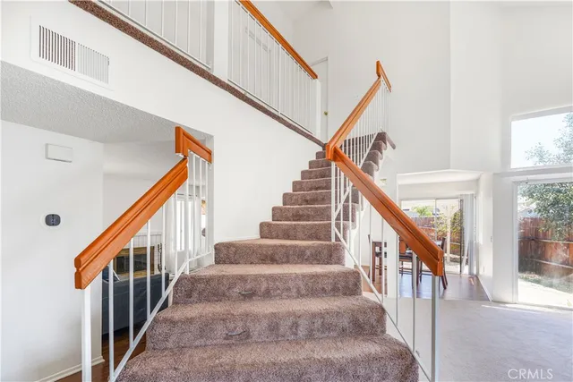 a view of staircase with lots of frames on wall and a window