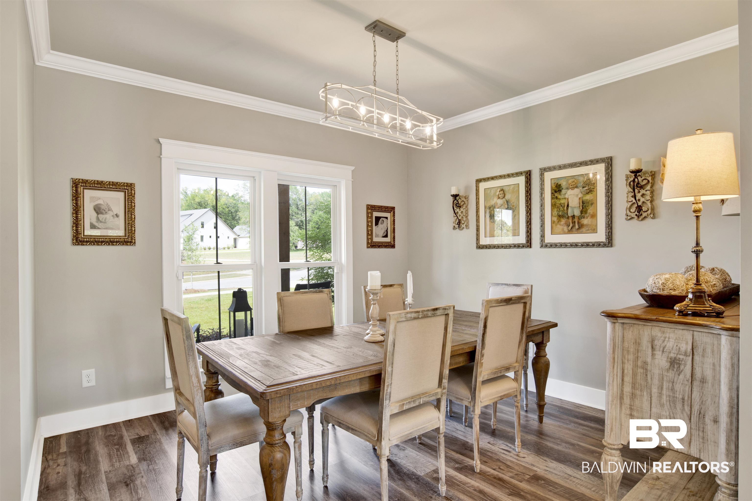 21621 Veranda Boulevard Fairhope, AL 36532 - Photo 26 of 51 Dining space with crown molding, baseboards, dark wood finished floors, and a chandelier