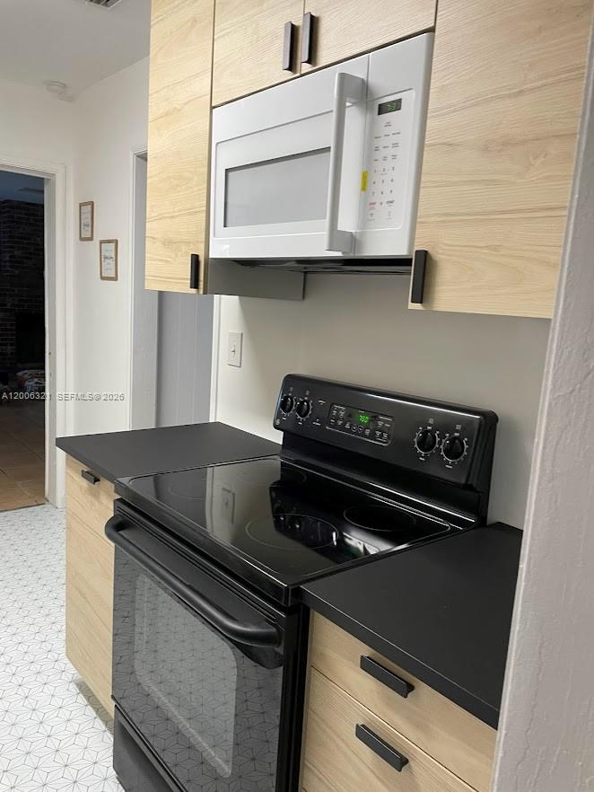 5800 Southwest 61st Street Miami, FL 33143 - Photo 22 of 23 a kitchen with stainless steel appliances granite countertop a stove and a microwave