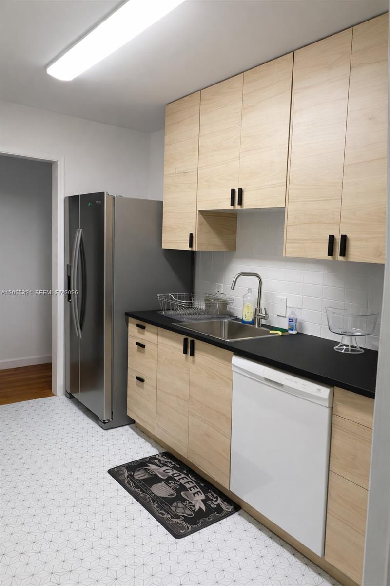 5800 Southwest 61st Street Miami, FL 33143 - Photo 3 of 23 a kitchen with granite countertop a sink cabinets and stainless steel appliances