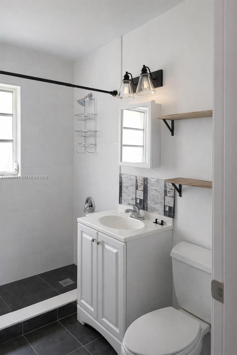 5800 Southwest 61st Street Miami, FL 33143 - Photo 10 of 23 a bathroom with a sink a toilet and a mirror