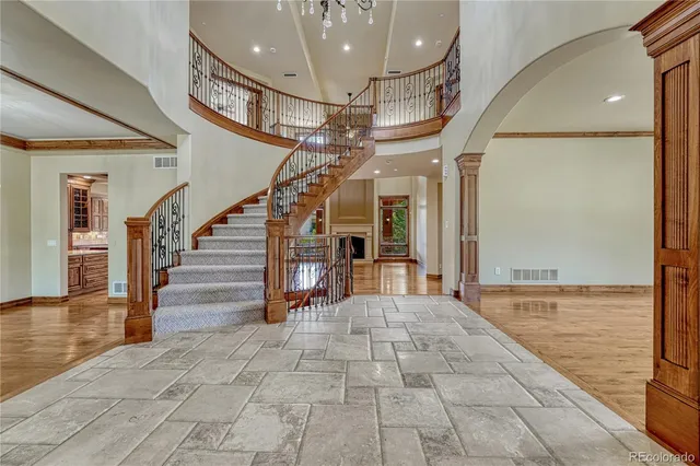 a view of an empty room with stairs and wooden floor