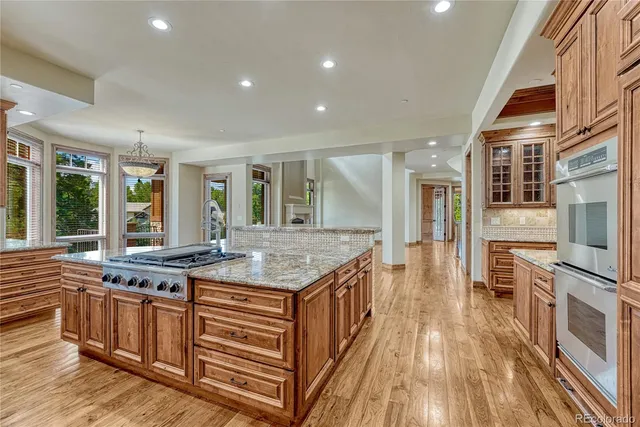 a bathroom with a granite countertop sink a toilet a mirror and shower