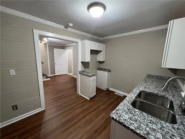 a kitchen with granite countertop a stove and cabinets