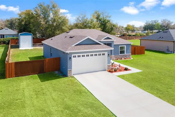 a view of a house with a yard and tree s