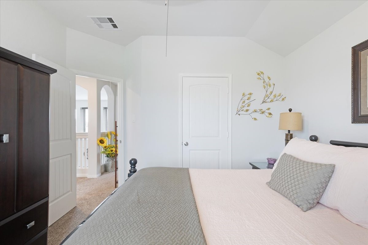 1685 County Road 5102 East Cleveland, TX 77327 - Photo 23 of 31 a bedroom with a bed and a chandelier
