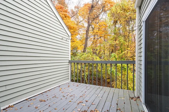 a view of a balcony with a white door and wooden floor