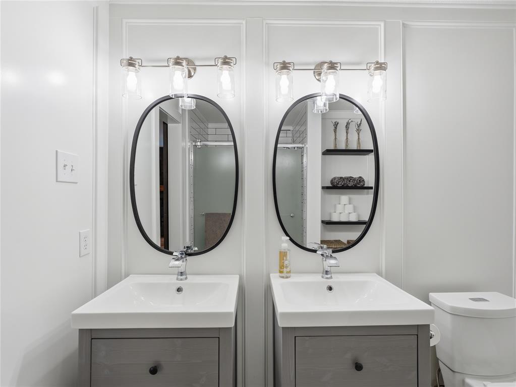 12724 Carpenter Lane Rhome, TX 76078 - Photo 18 of 37 Dual vanities featuring contemporary gray cabinetry, rectangular white sinks, and chrome faucets