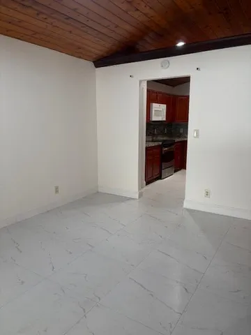 a view of an empty room with kitchen