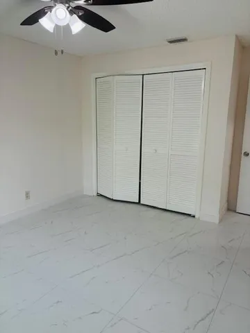 an empty room with chandelier fan