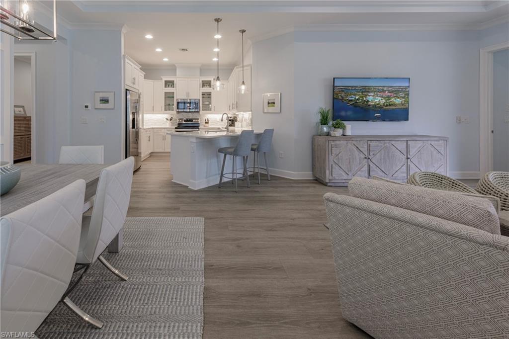 5906 Haiti Drive Naples, FL 34113 - Photo 13 of 44 a living room with stainless steel appliances furniture a rug kitchen view and a chandelier