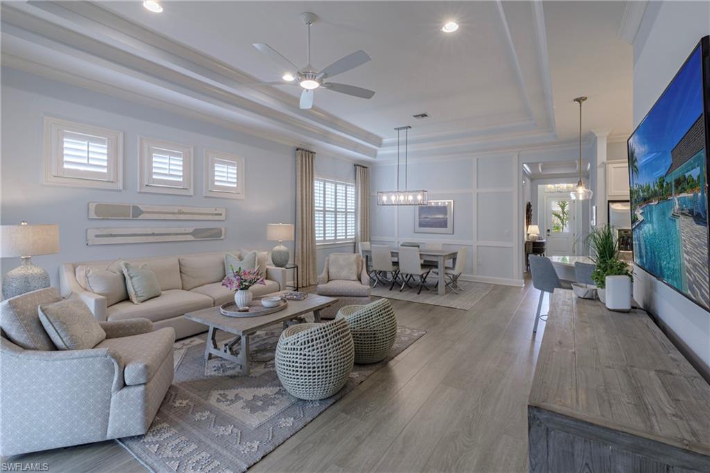 5906 Haiti Drive Naples, FL 34113 - Photo 20 of 44 a living room with furniture a large window and wooden floor