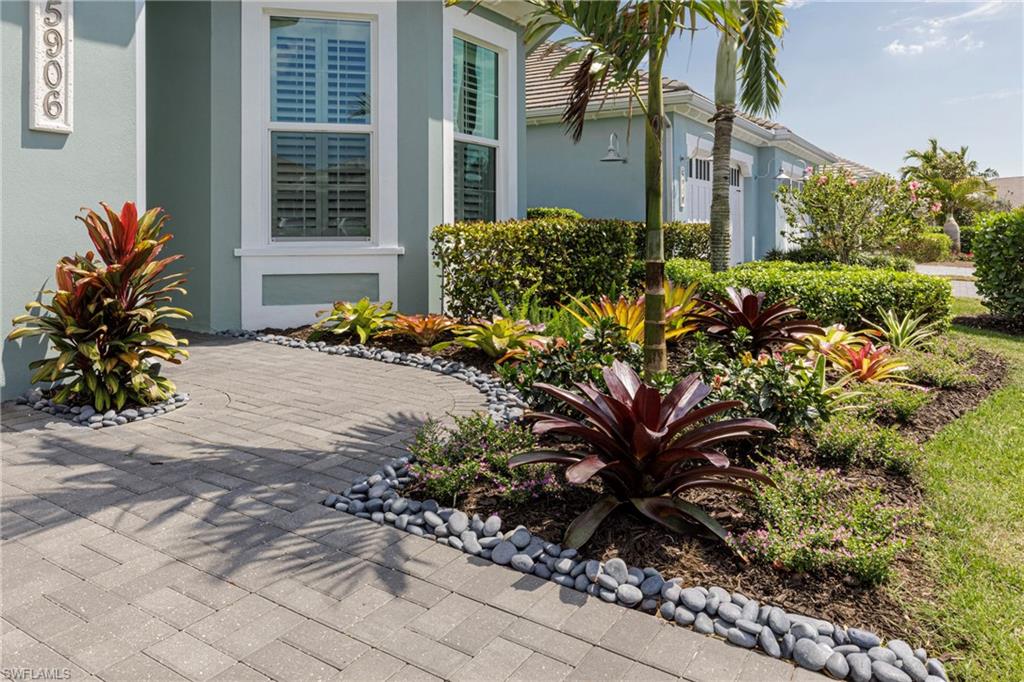 5906 Haiti Drive Naples, FL 34113 - Photo 2 of 44 a view of a house with a flower garden