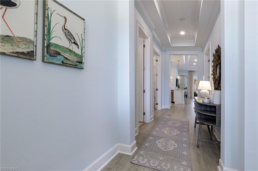 5906 Haiti Drive Naples, FL 34113 - Photo 3 of 44 a view of a hallway with wooden floor and a bathroom