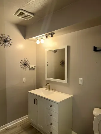 a bathroom with a sink mirror and toilet