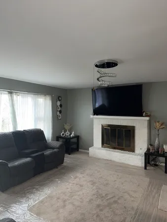 a living room with furniture a fireplace and a large window