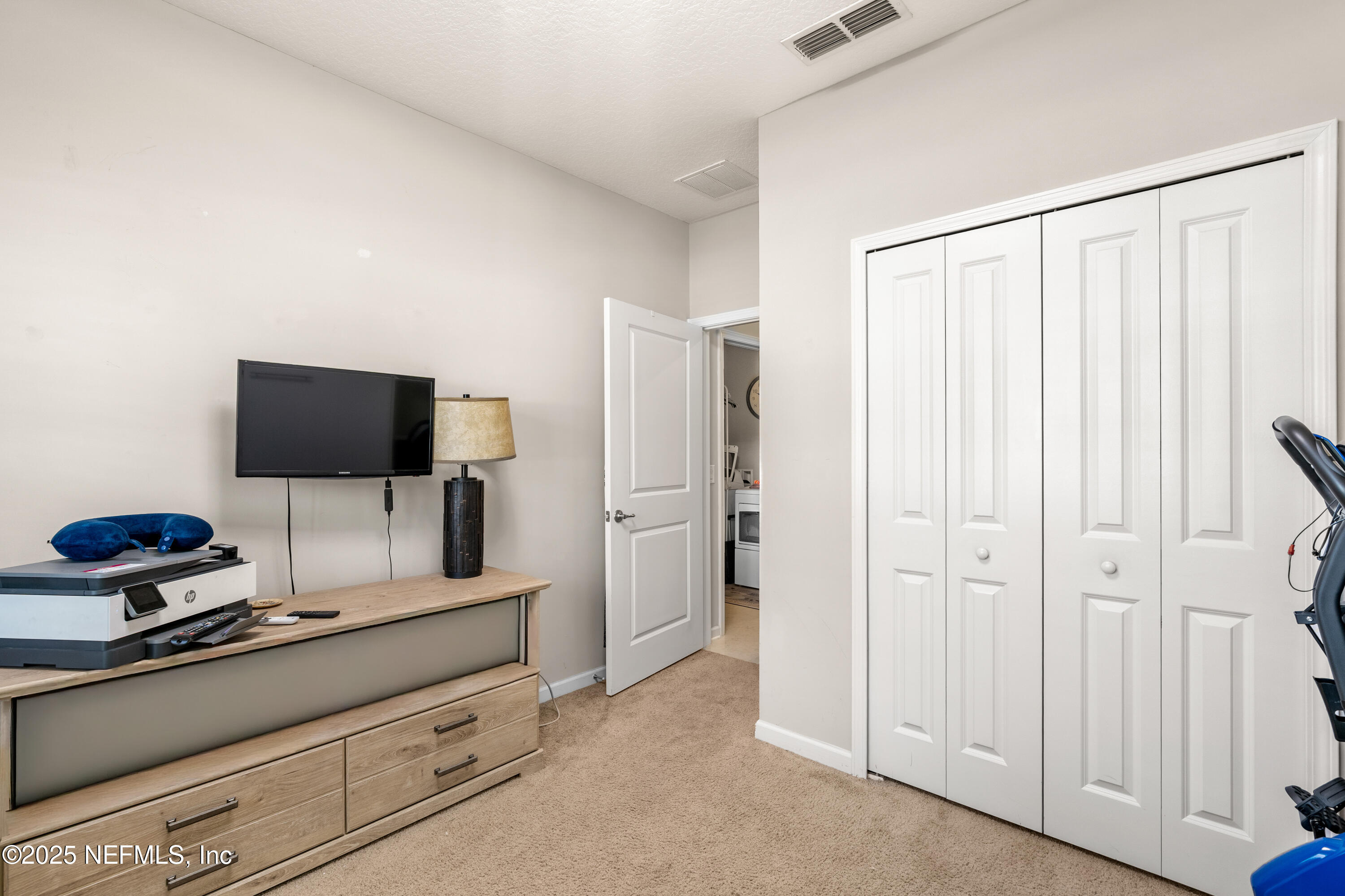 3165 Chestnut Ridge Way Orange Park, FL 32065 - Photo 18 of 35 a bedroom with a bed and a flat tv screen on the dresser