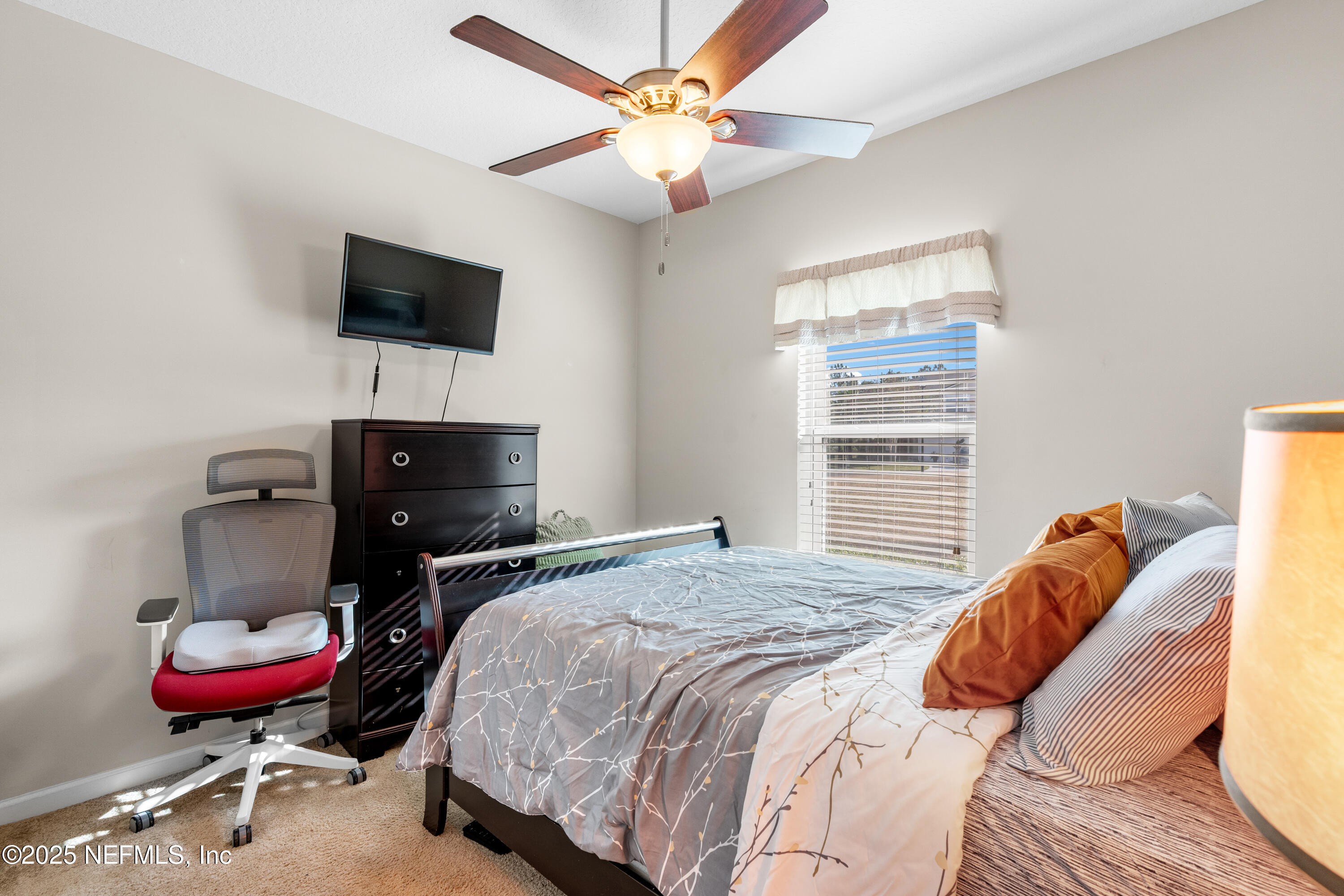 3165 Chestnut Ridge Way Orange Park, FL 32065 - Photo 20 of 35 a bedroom with a bed and a flat screen tv