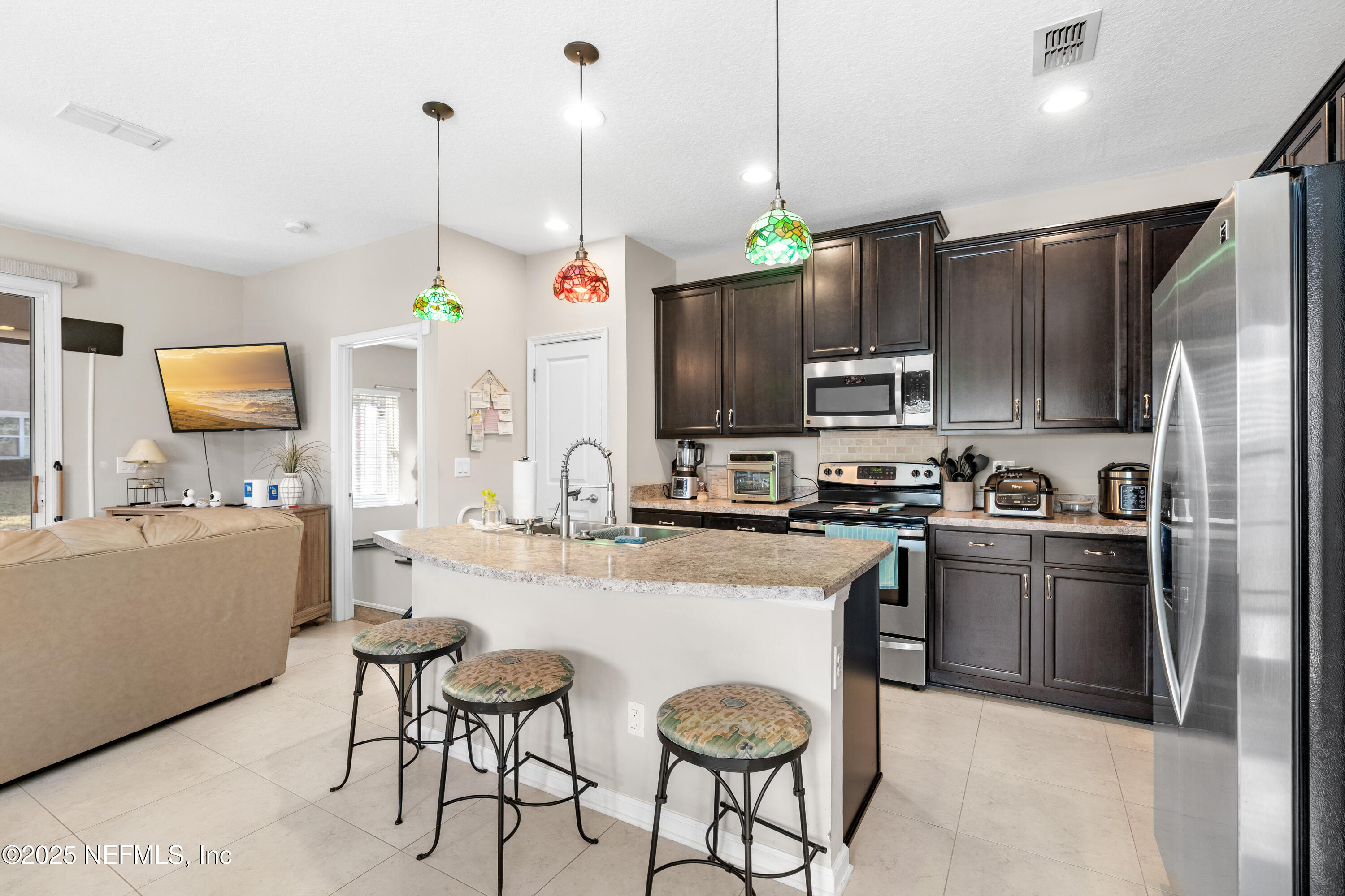 3165 Chestnut Ridge Way Orange Park, FL 32065 - Photo 5 of 35 a kitchen with stainless steel appliances granite countertop a sink a stove a refrigerator cabinets and chairs