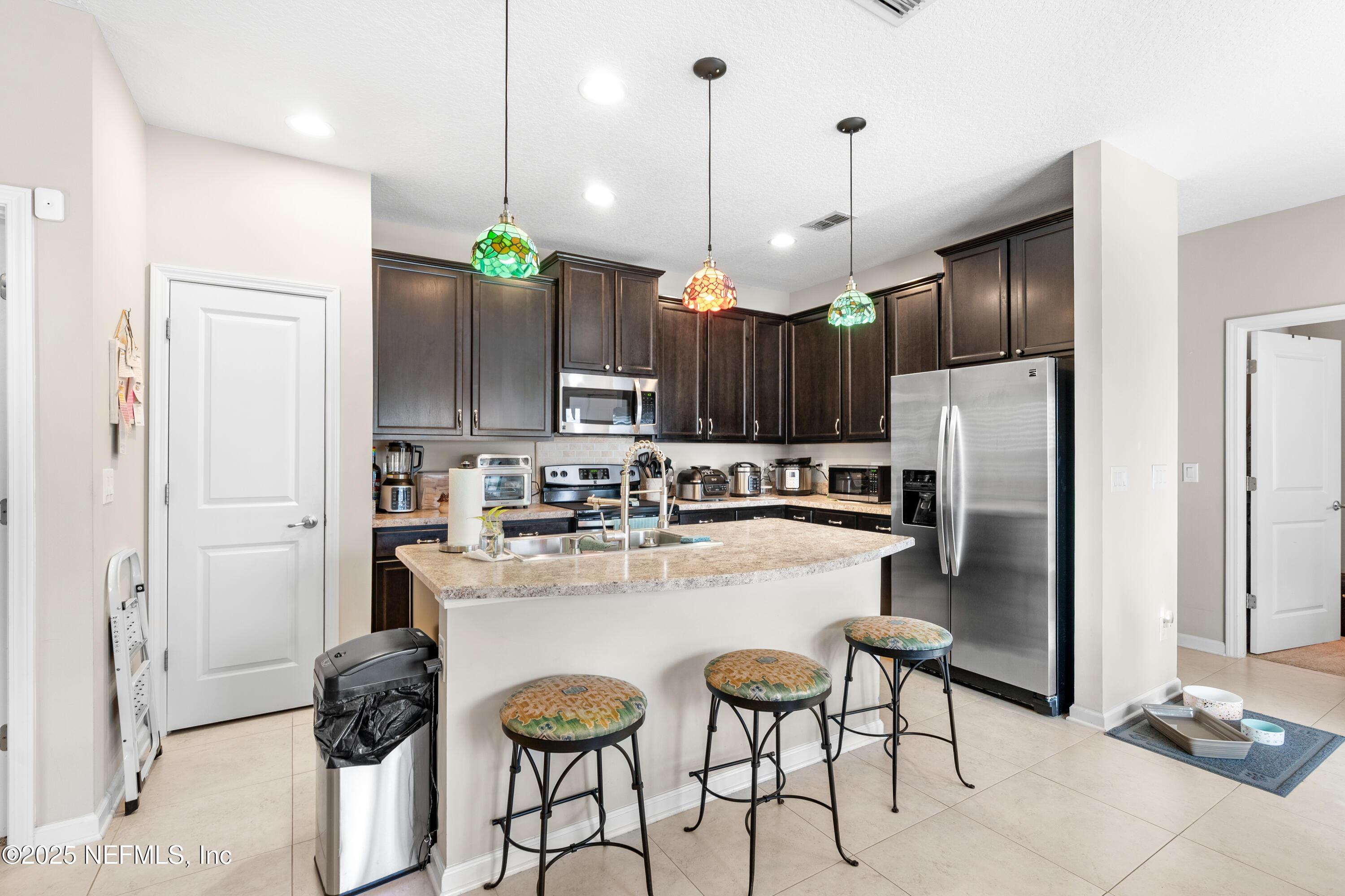 3165 Chestnut Ridge Way Orange Park, FL 32065 - Photo 6 of 35 a kitchen with kitchen island a counter and chairs