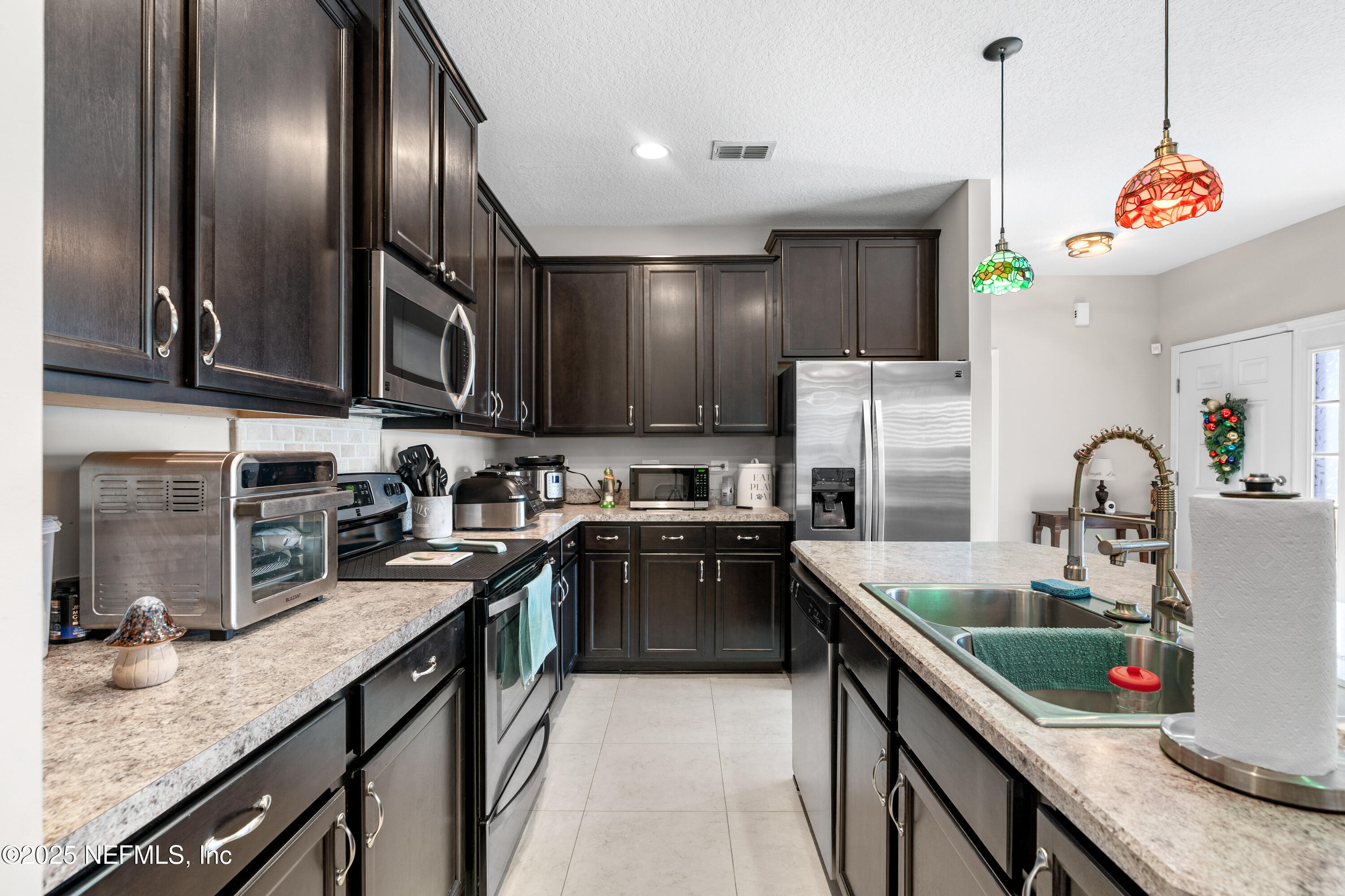 3165 Chestnut Ridge Way Orange Park, FL 32065 - Photo 7 of 35 a kitchen with kitchen island granite countertop stainless steel appliances a sink stove top oven and cabinets