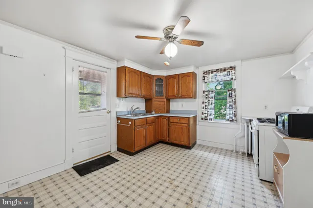 a kitchen with a refrigerator a stove top oven and cabinets