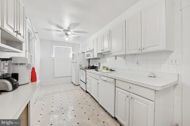 a kitchen with granite countertop a sink cabinets stainless steel appliances and a counter space