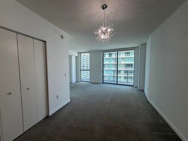 an empty room with windows and chandelier