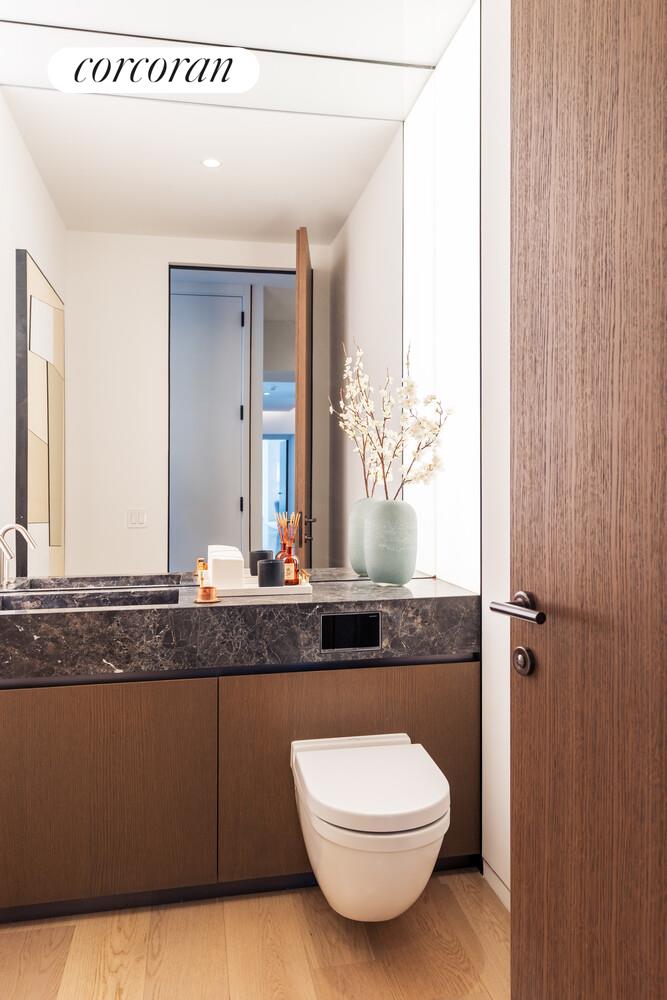 100 East 53rd Street, Unit 10A Manhattan, NY 10022 - Photo 24 of 35 a bathroom with a granite countertop sink a mirror and a toilet