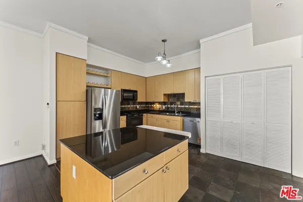 a kitchen with stainless steel appliances granite countertop a refrigerator a sink and a stove