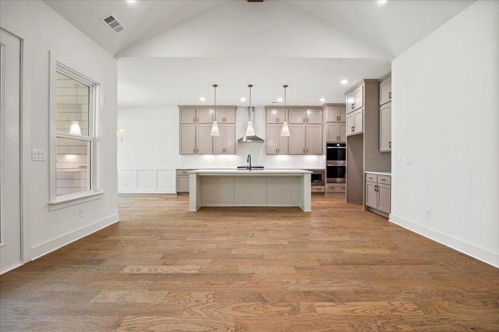 8280 Scarlett Grace Lane Gainesville, GA 30506 - Photo 21 of 48 a view of kitchen with stainless steel appliances kitchen island empty cabinets and wooden floor