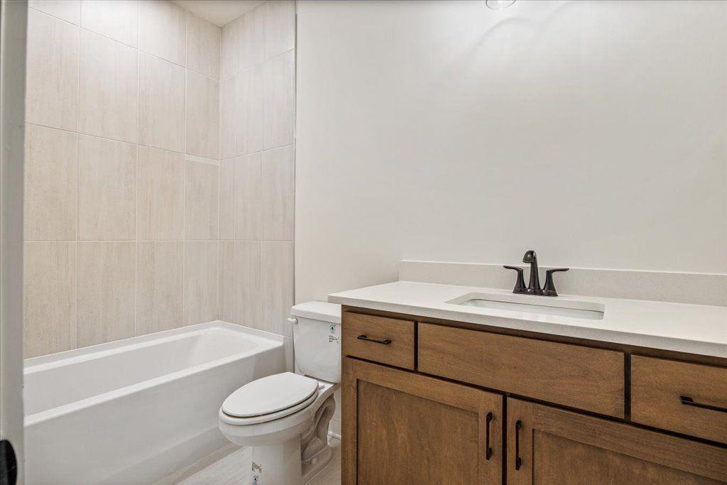 8280 Scarlett Grace Lane Gainesville, GA 30506 - Photo 35 of 48 a bathroom with a granite countertop toilet a sink and a bathtub