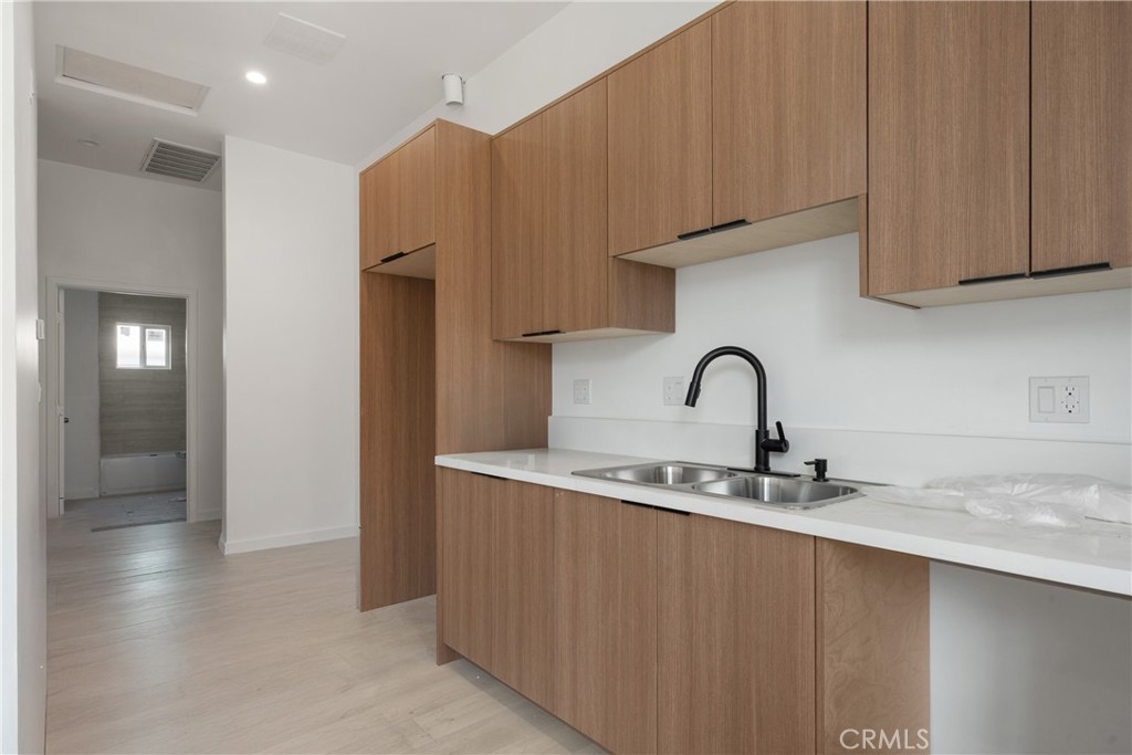 3929 Brighton Avenue, Unit 1/2 Los Angeles, CA 90062 - Photo 4 of 7 a kitchen with stainless steel appliances granite countertop a sink a stove and a refrigerator with wooden cabinets