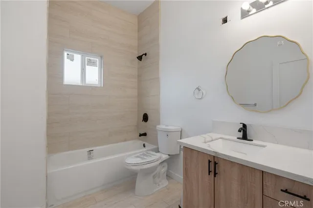 a bathroom with a toilet a sink a mirror and bathtub
