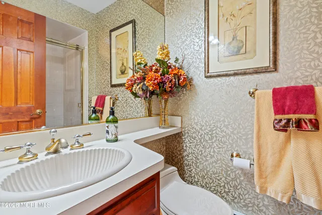 a spacious bathroom with a double vanity sink toilet and a mirror