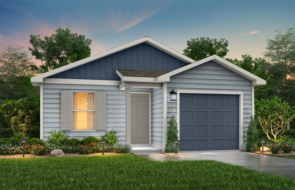 View of front of home featuring a garage and a yard