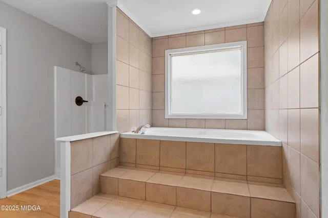 an empty room with wooden floor and window